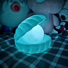 A glowing Pearl Shell Night Lamp on a light-colored surface, showcasing its unique design.
