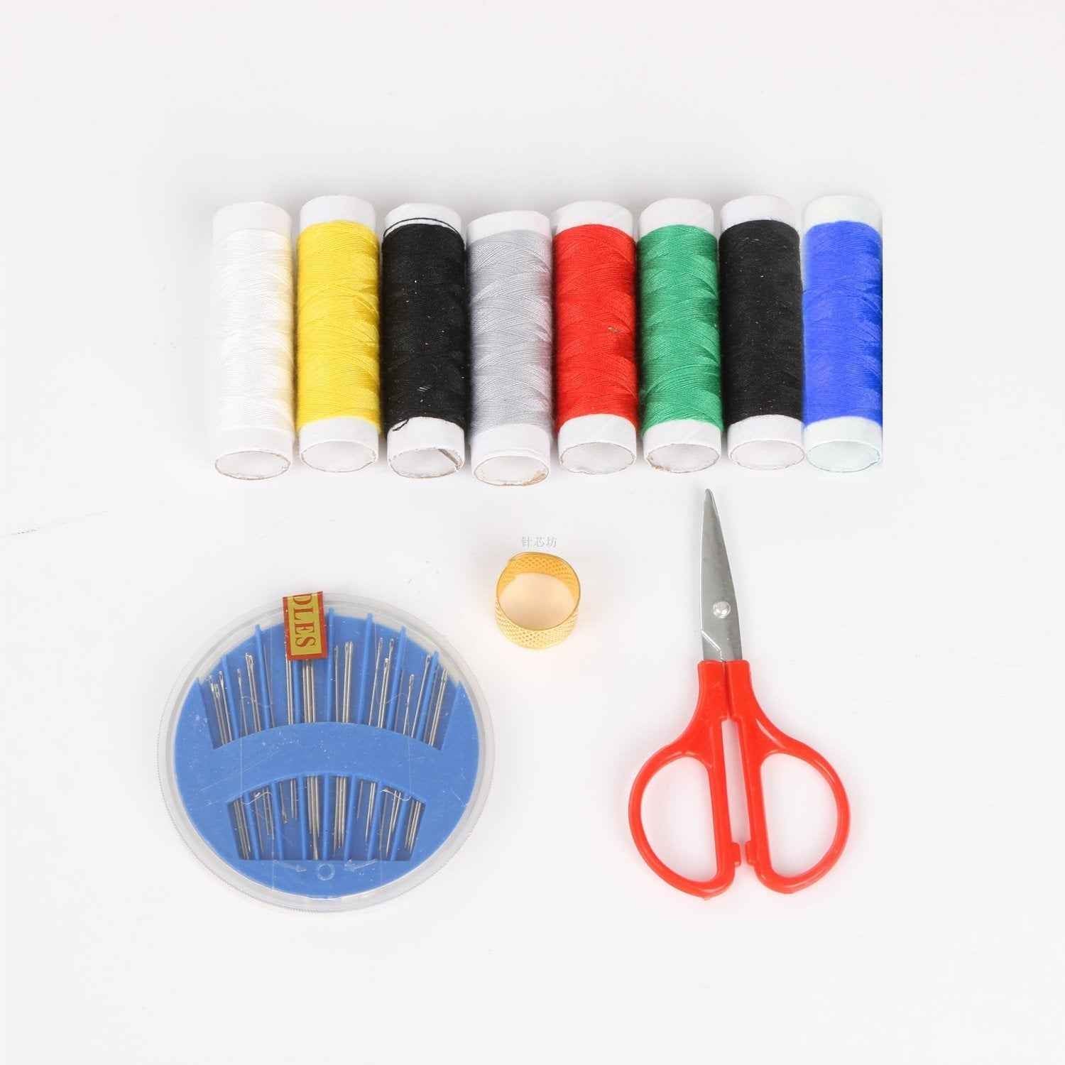 Sewing kit for home tailoring with bobbins, threads, and scissors.