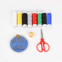 Sewing kit for home tailoring with bobbins, threads, and scissors.