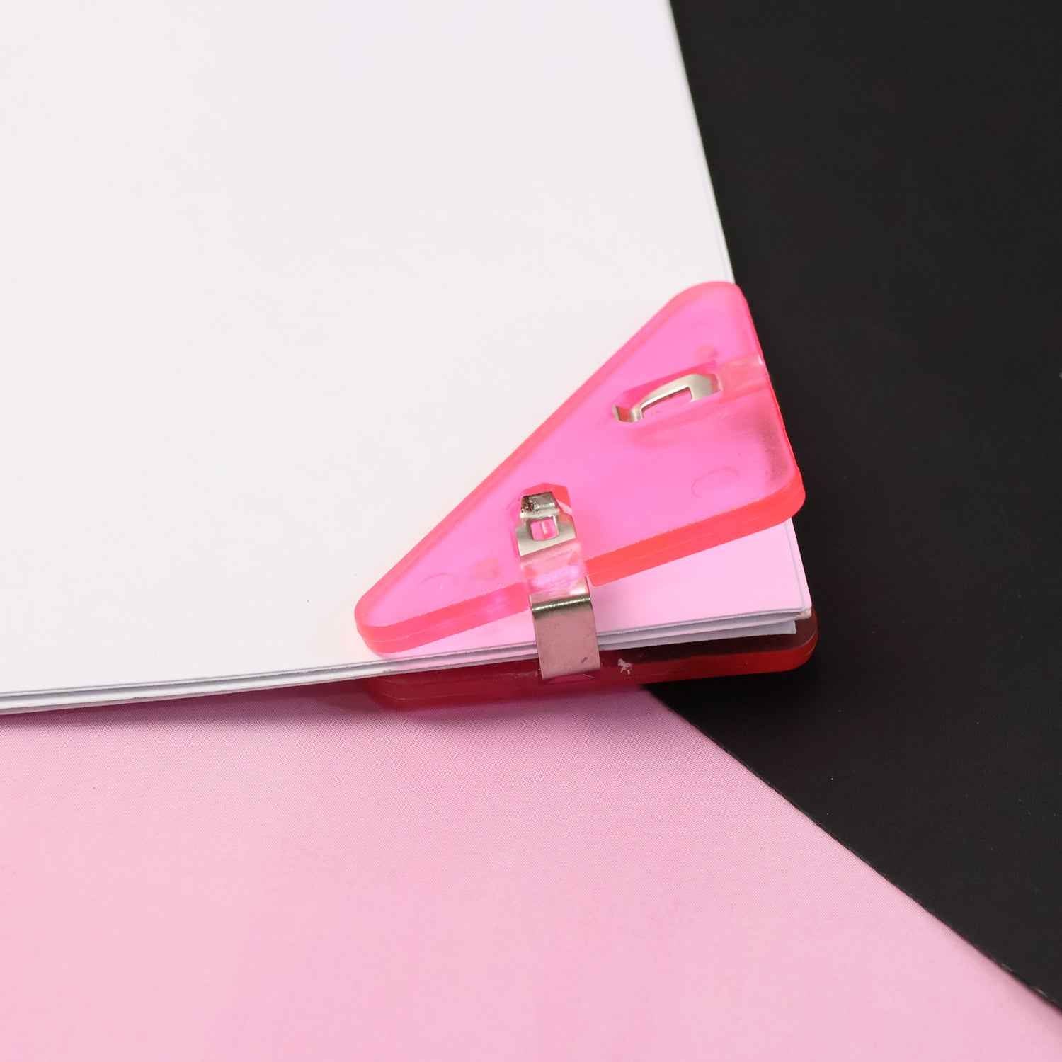 Close-up of durable triangle paper clip securing paper corner
