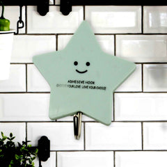 A set of strong self-adhesive hooks displayed neatly on a tiled kitchen wall, ready for use.
