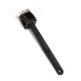 Black silicone toilet brush with its draining holder, ready for use in a modern bathroom.