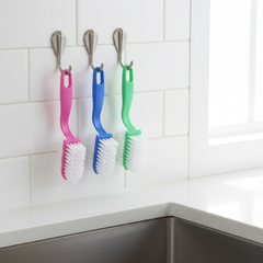 Kitchen cleaning brush effectively removing scales from a fish.