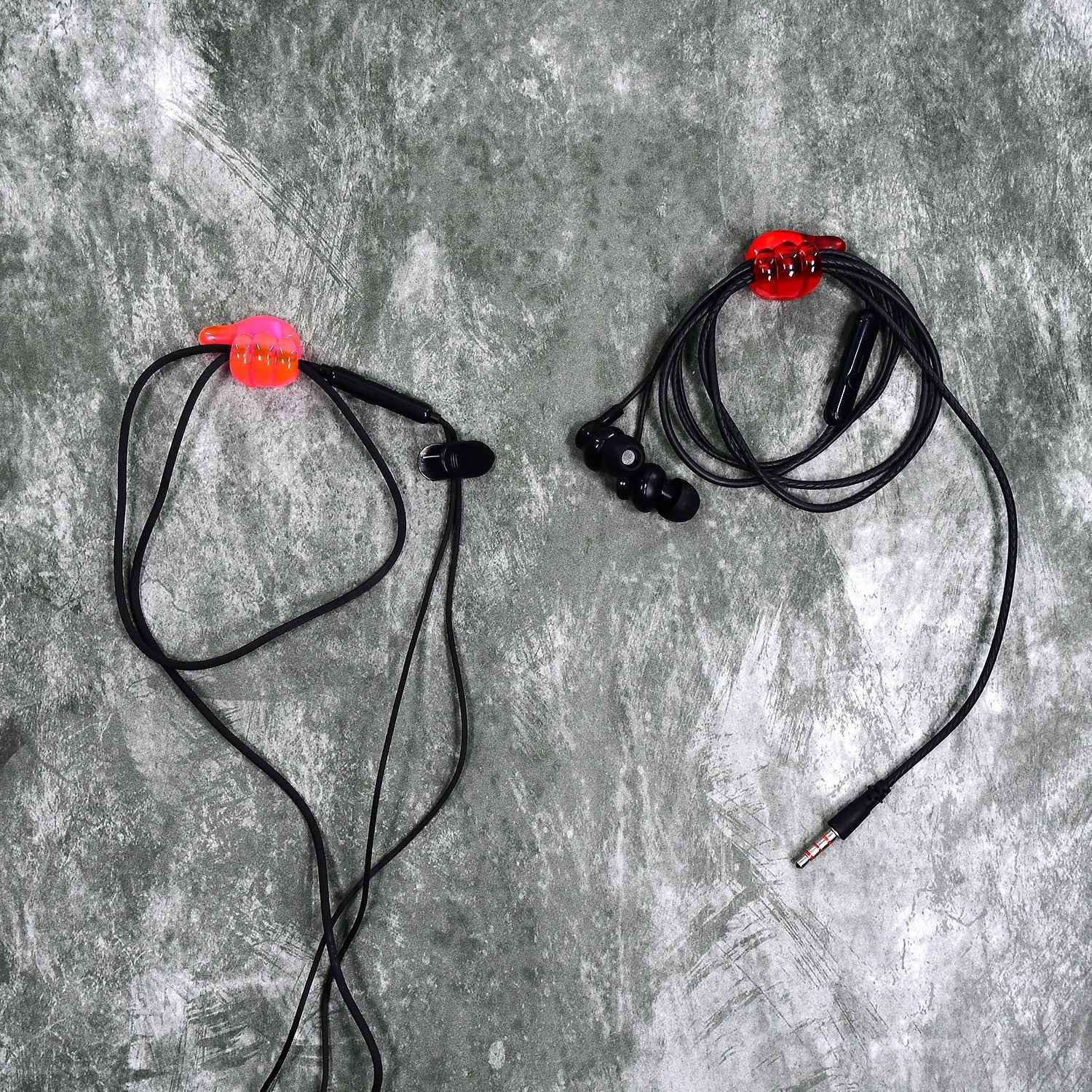 A set of multi-functional hand shape wall clips holding various items like cables and keys.