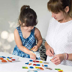Assorted foam magnetic letters in yellow, green, and pink on a plain surface.
