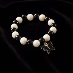 Close-up of black and white beads and cross pendant on bracelet