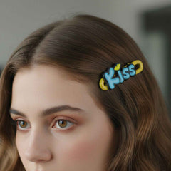 Close-up image of four Kiss text hair clips showing letter design