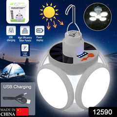 A white Quickslice solar camping light with four bright LED panels illuminates a dark campsite with a tent.