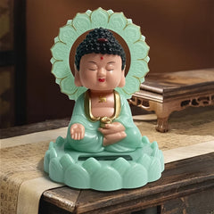 Front view of the solar-powered moving head Buddha statue on a dark background.