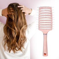 Massage hair comb placed on wooden surface highlighting ergonomic grip