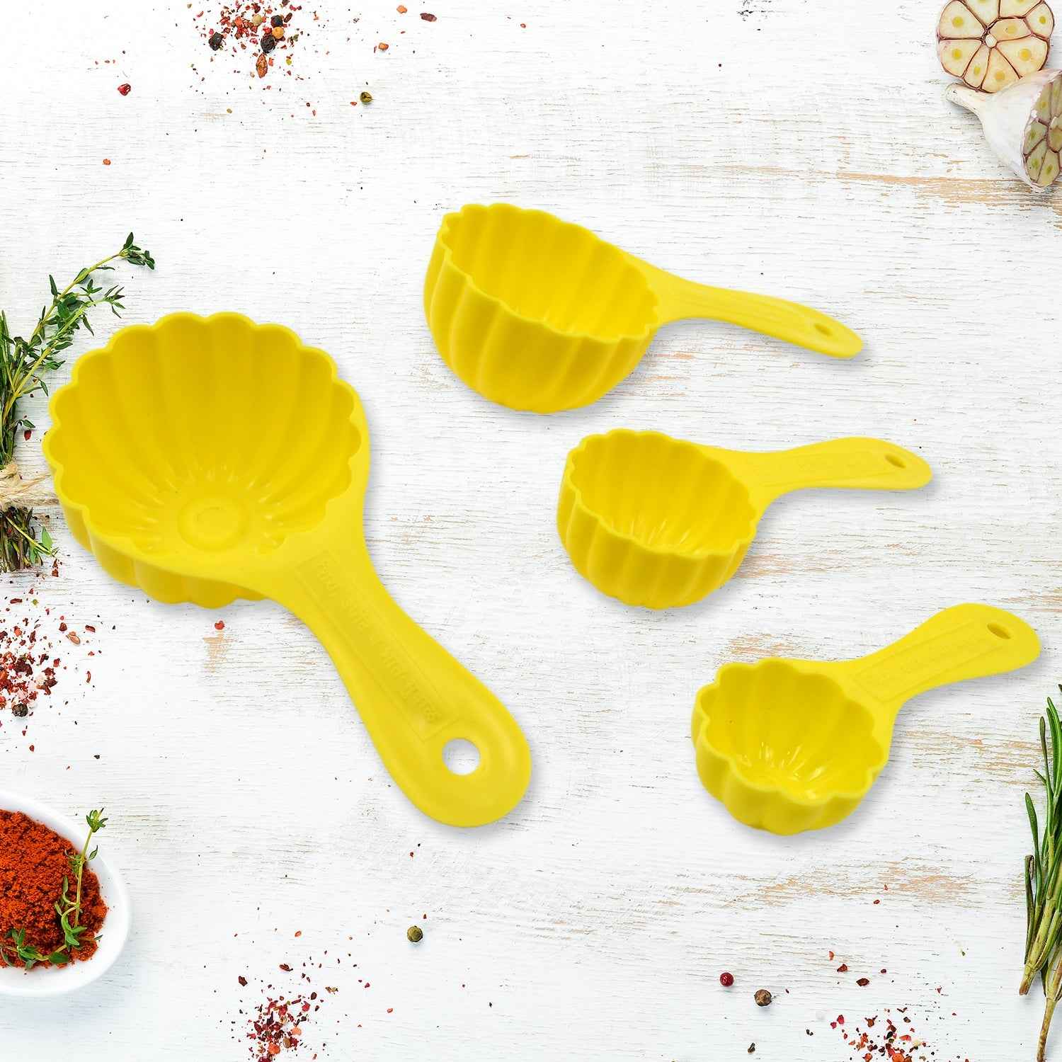 A 4-piece plastic ladoo making spoon set, displayed with an additional serving spoon.