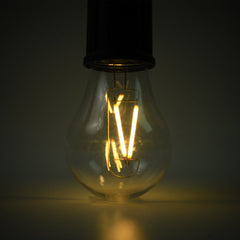 A close-up of the clear bulb of a portable LED tent light shows the glowing orange filament against a dark background.