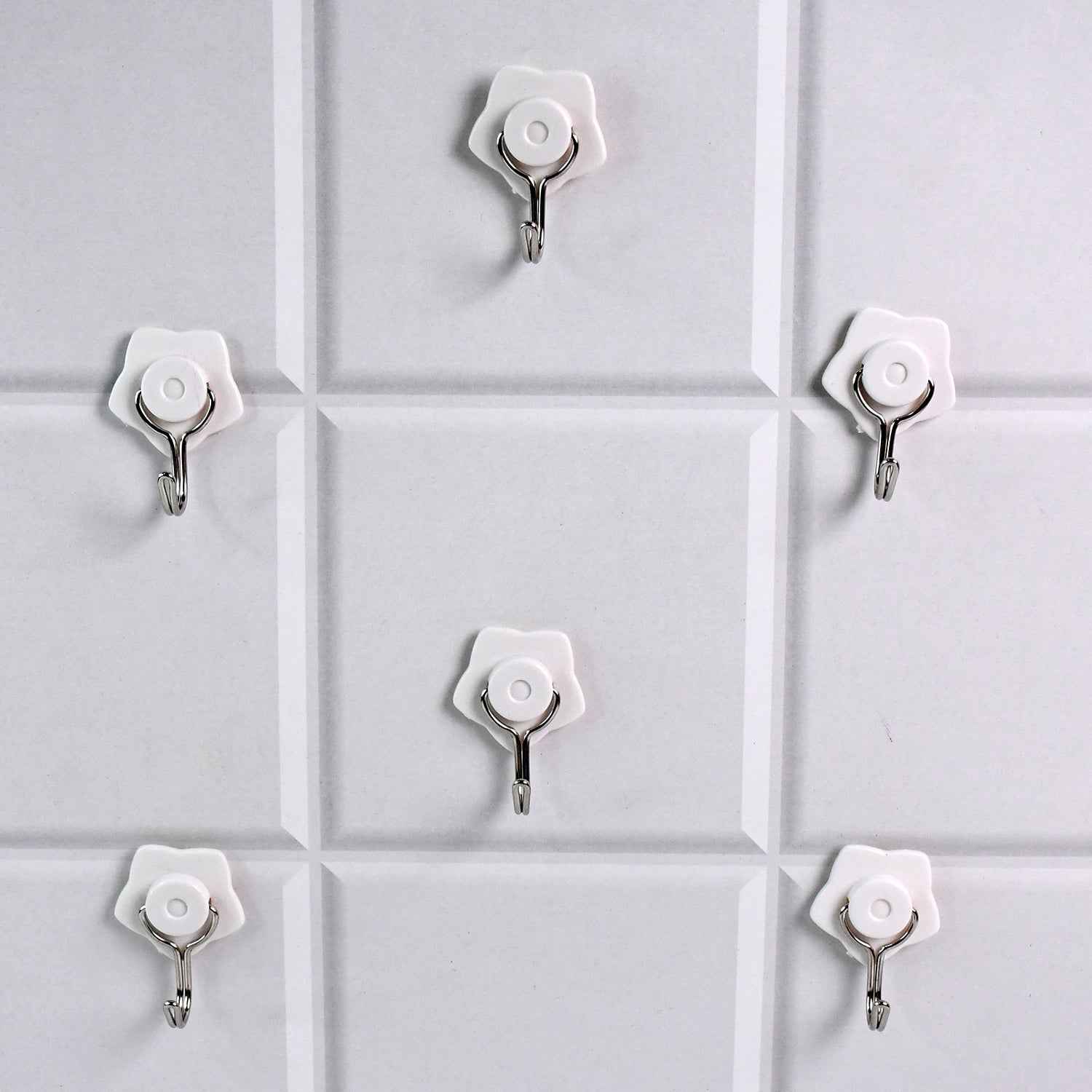 A yellow self-adhesive hook securely holding a towel in a modern bathroom.