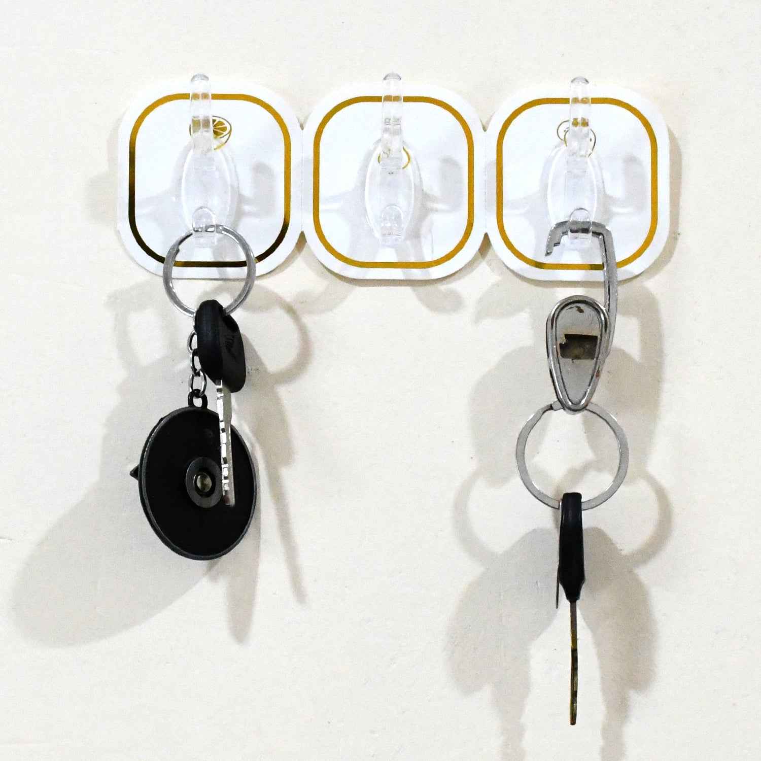 Close-up of a clear plastic transparent adhesive hook with a stainless steel hook.