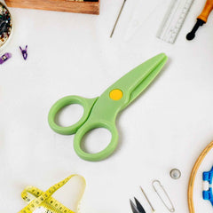 Plastic safety scissors placed on a craft table for toddlers