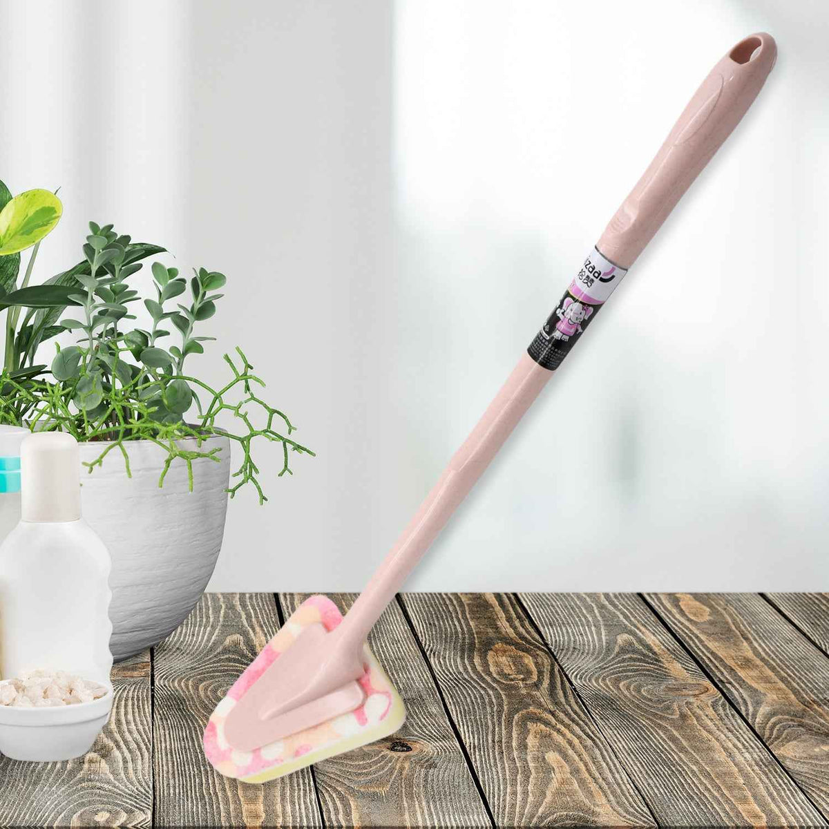 Triangular cleaning brush with long handle, ready for kitchen use.