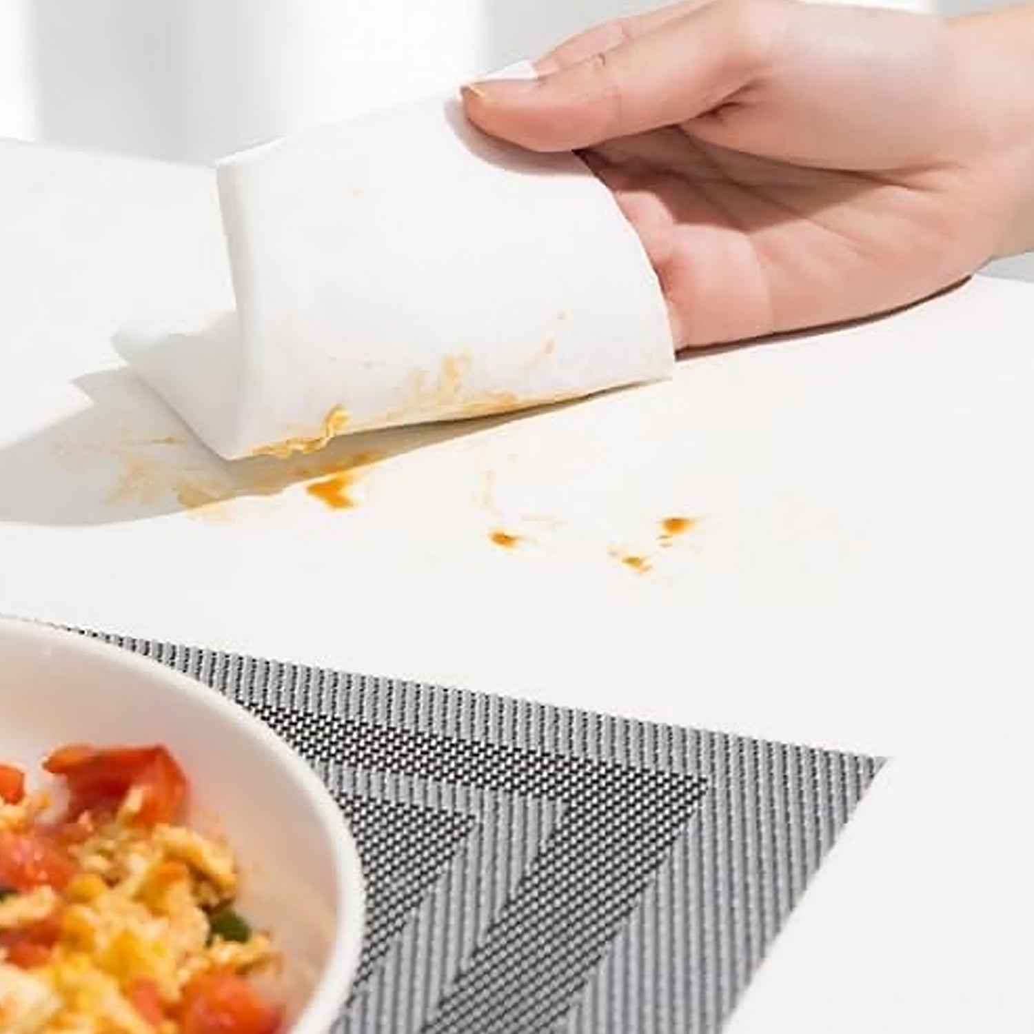 A used kitchen cleaning wipe effectively removing stubborn oil stains from a counter.