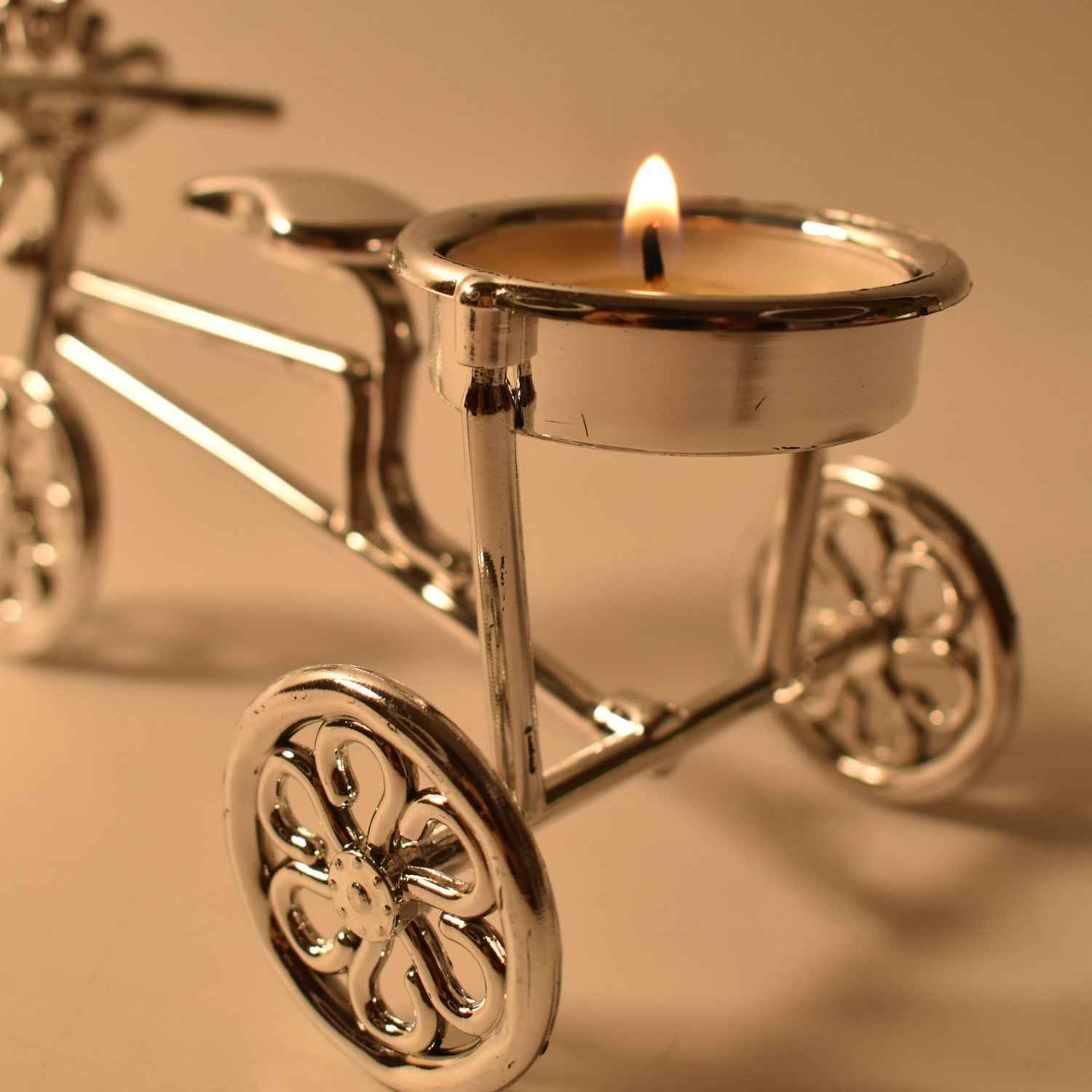 Close-up of tealight candle burning on decorative cycle stand holder