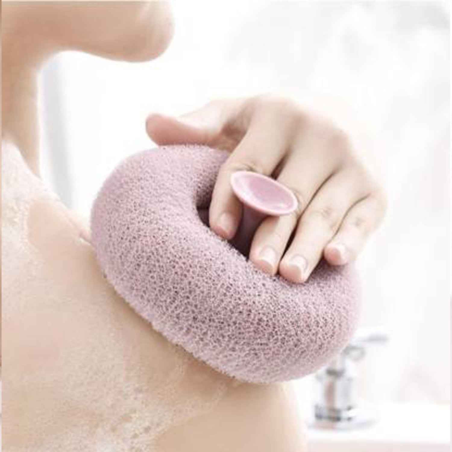 A hand holding the flower-shaped bath sponge during a refreshing shower.