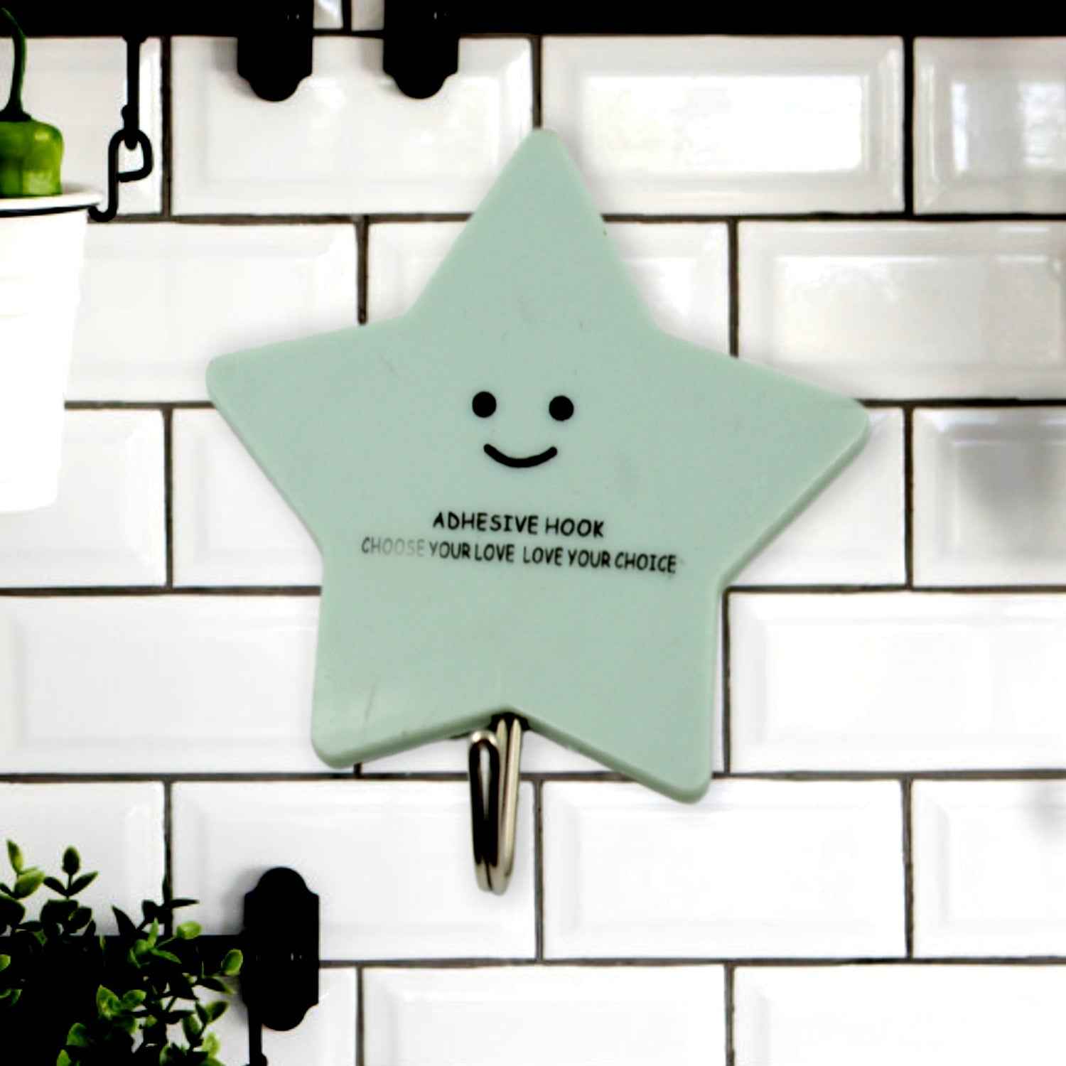 A set of strong self-adhesive hooks displayed neatly on a tiled kitchen wall, ready for use.