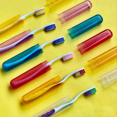 A manual toothbrush securely stored inside a clear plastic travel cover.