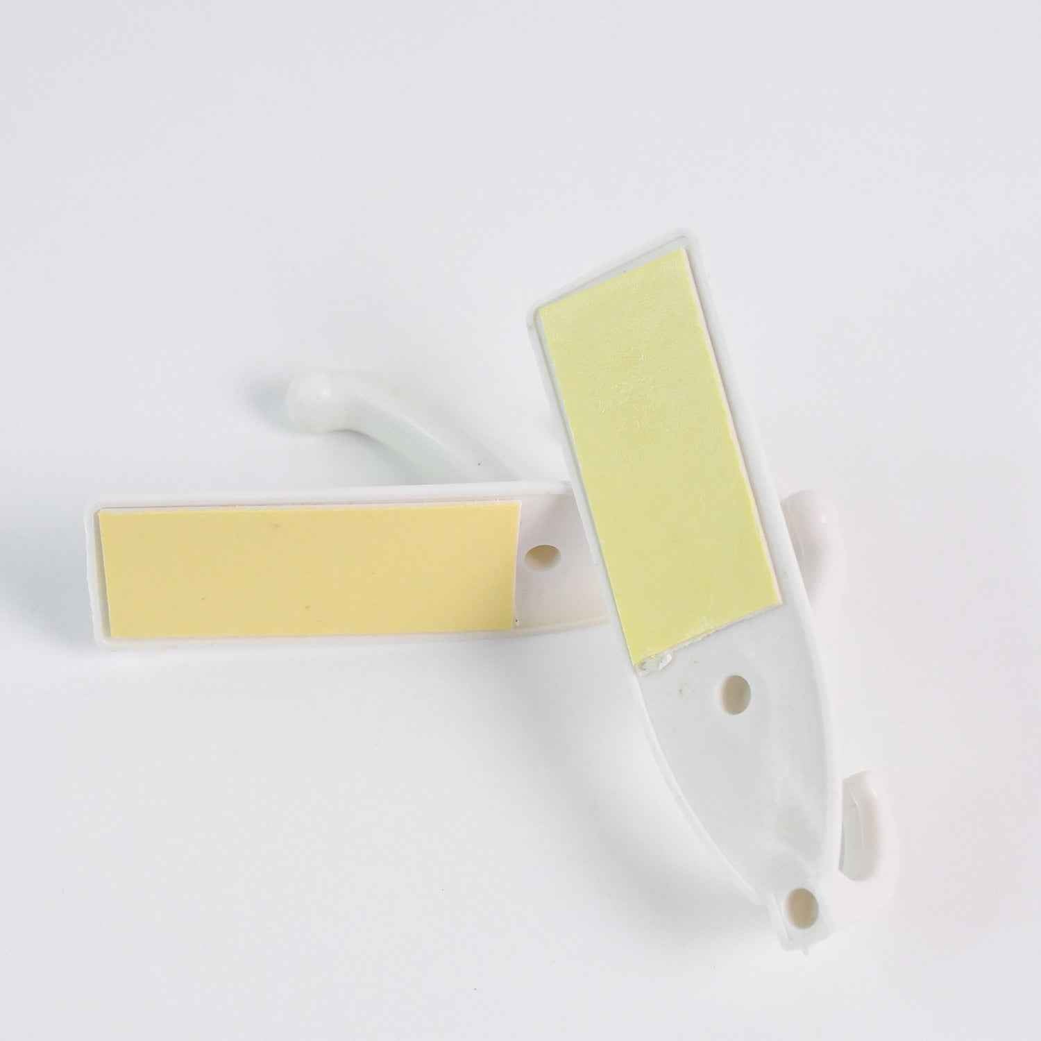 Easy application of a self-adhesive wall hook on a smooth surface with hanging items.