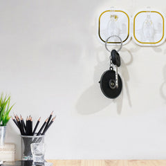 Transparent adhesive wall hook securely holding a heavy object, demonstrating its 3kg load capacity.