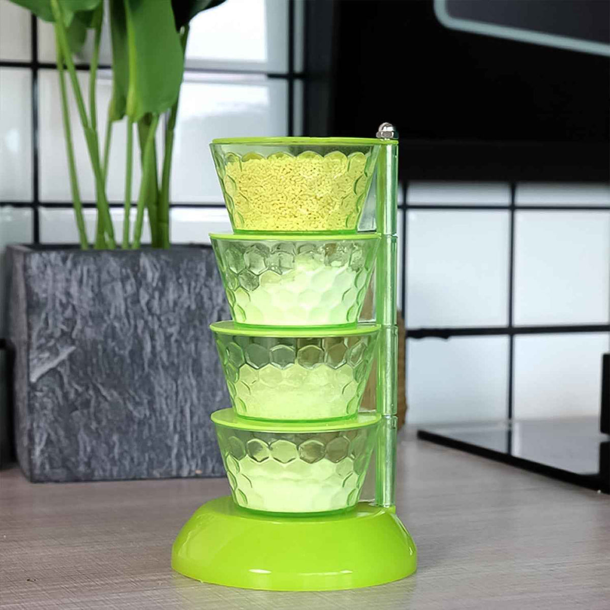  4-tier rotating spice rack with four transparent compartments and spoons.