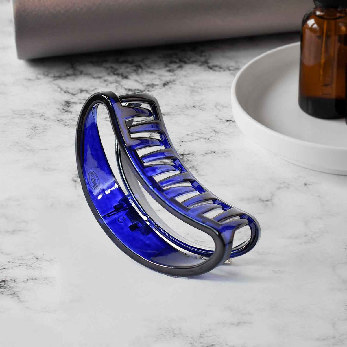 Plastic hair clamp grip with matte finish holding thick hair securely.