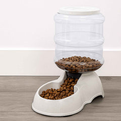 White automatic pet food dispenser with clear food storage bottle for dry kibble