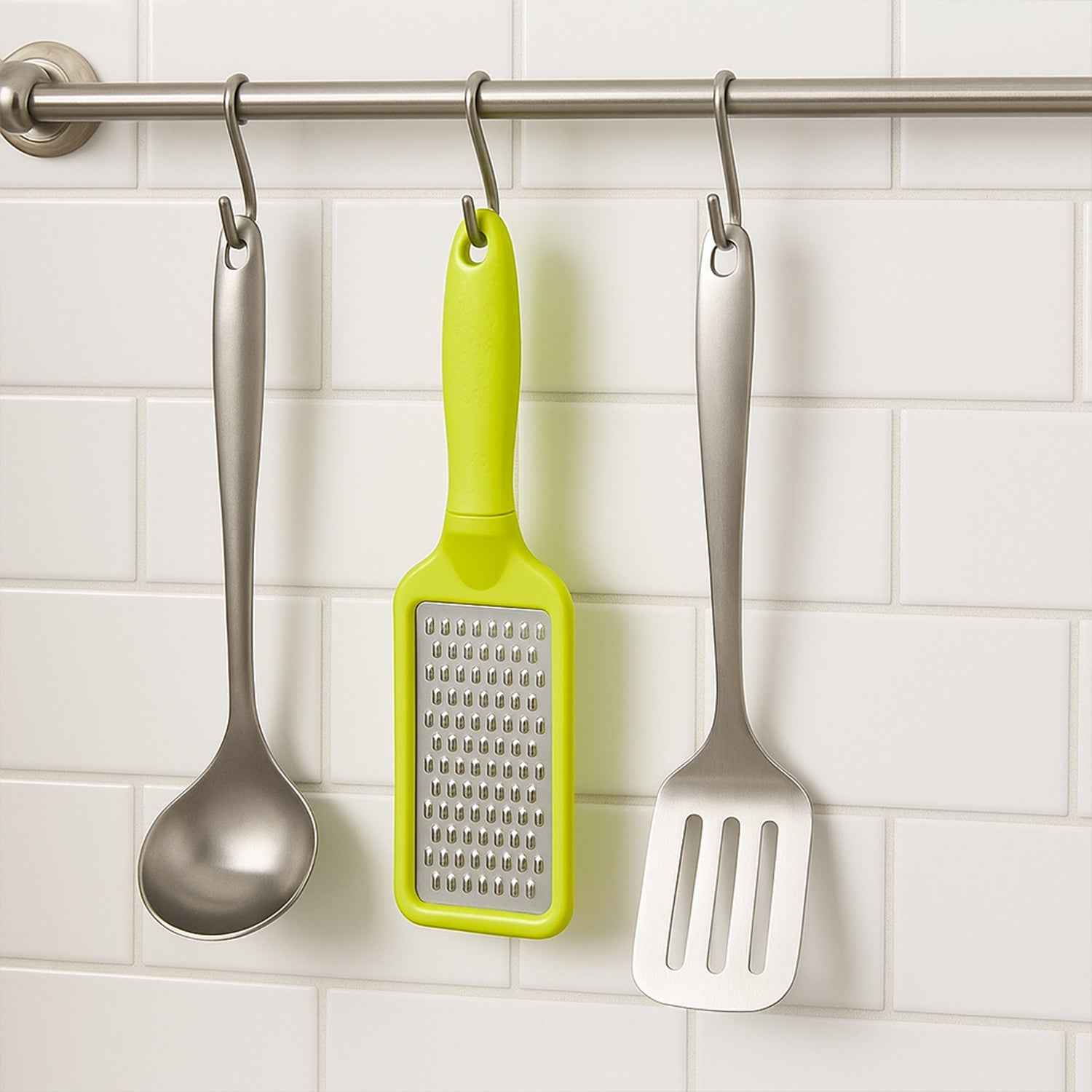 The ergonomic black plastic handle of the stainless steel grater, designed for a comfortable grip.
