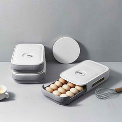 A clear plastic egg storage box with a drawer style, holding eggs inside a refrigerator.