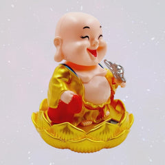 The Solar Buddha Car Ornament placed on a lotus base, perfect for car decor.