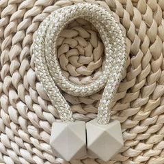 Pair of hexagonal magnetic curtain tiebacks elegantly holding a sheer curtain.