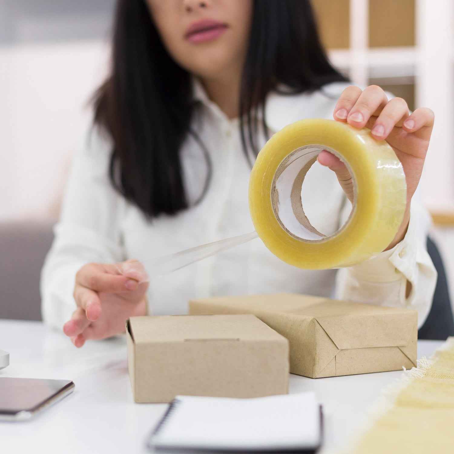 Transparent packing tape roll, high adhesive, for secure sealing.