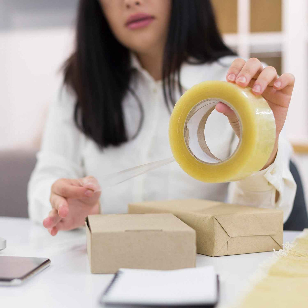 Transparent packing tape roll, high adhesive, for secure sealing.