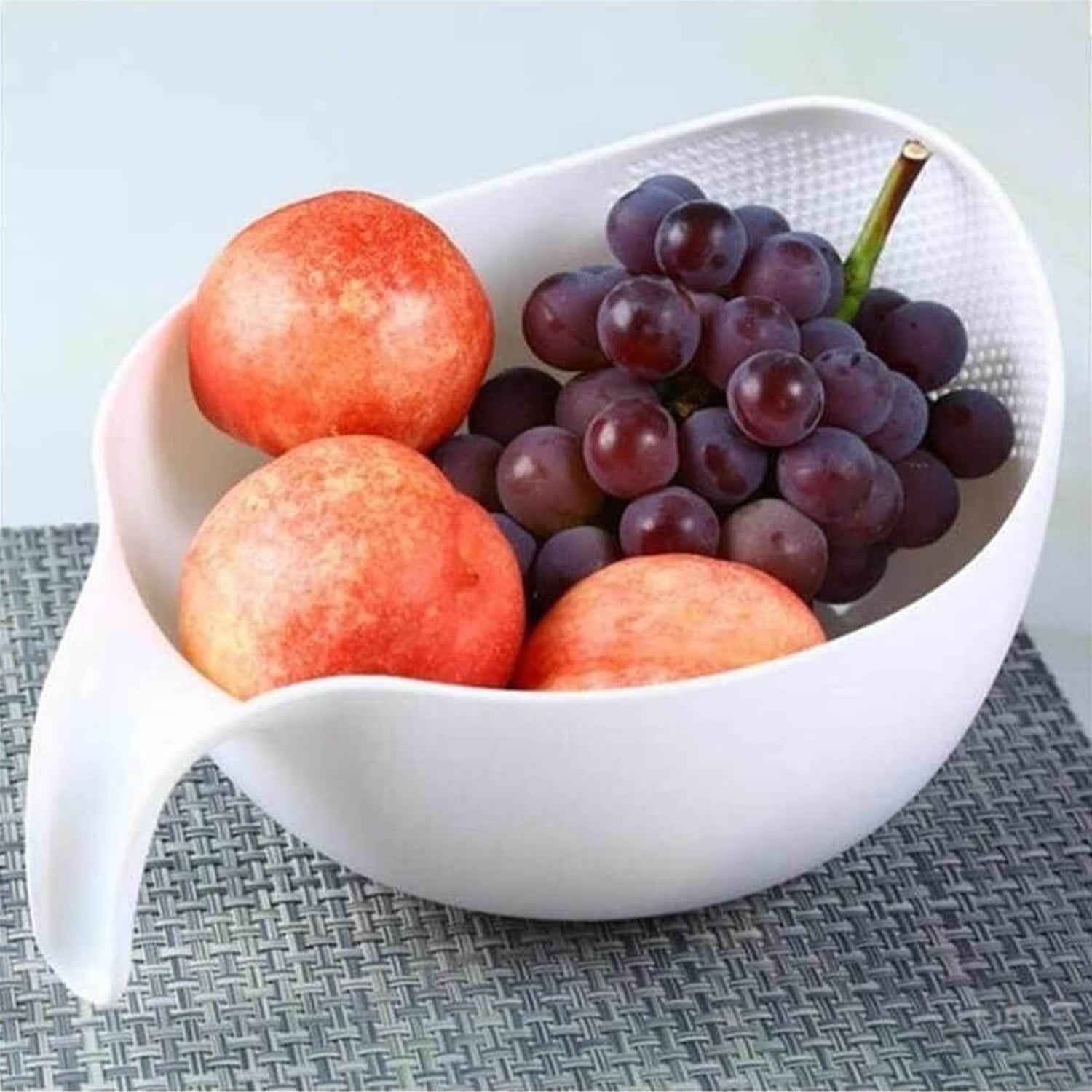 Multi-purpose plastic food strainer with a sturdy handle for various kitchen tasks.
